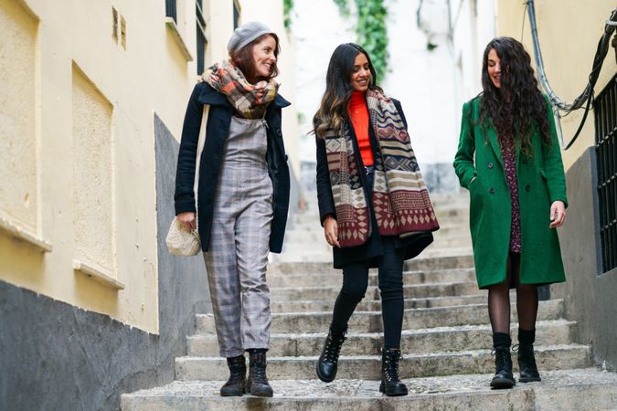Three well dressed female friends walking down stairs