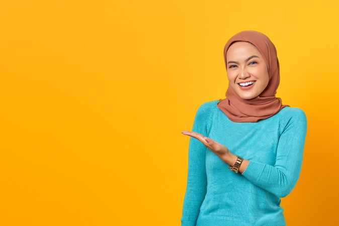 Muslim woman happy and gesturing to copy space