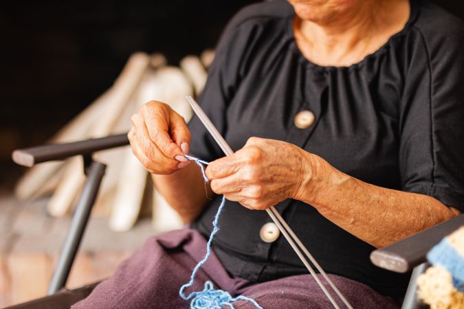 Ageless artistry, Latina woman weaves yarn with skill.