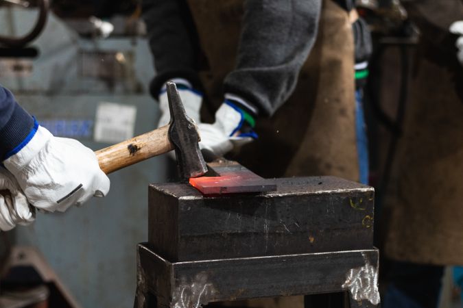 Blacksmiths forging hot iron in smithy