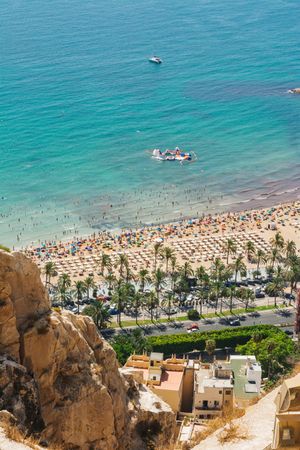 Stunning turquoise water and seashore with people palms boats