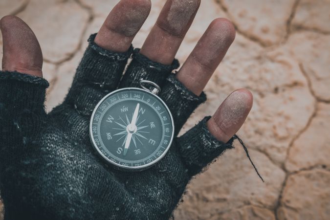 Compass in hand on dry desert area