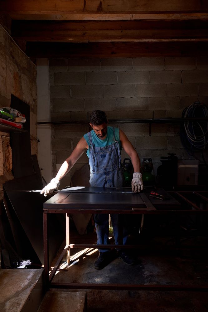 Focused man standing at workbench in dark garage