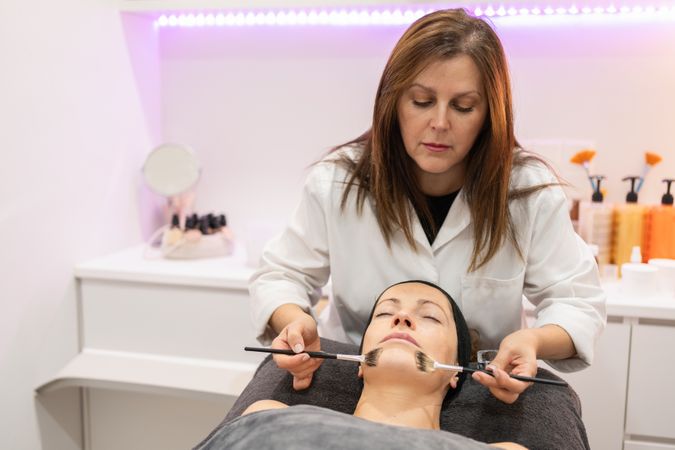 Client in beauty spa receiving facial