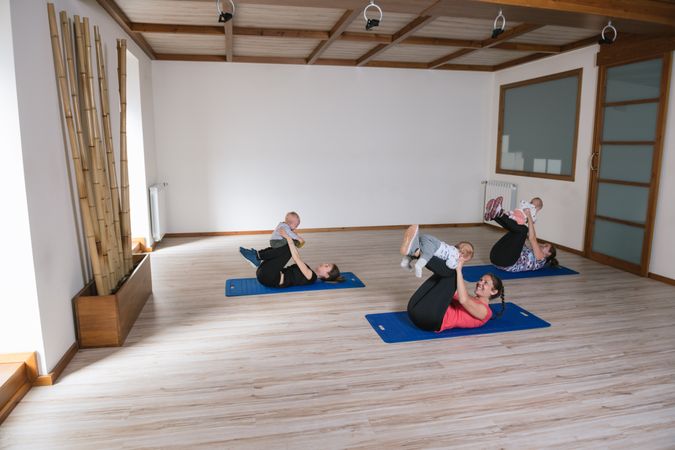 Mothers exercising with babies in gym