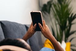 Young woman enjoys music and phone