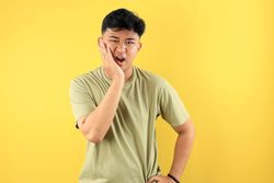 Asian Young Man Holding His Cheek, Dental Problem Concept