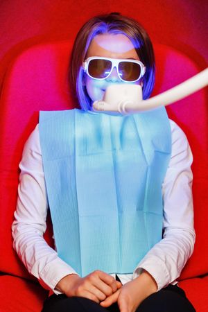 Female in protective glasses during dental procedure