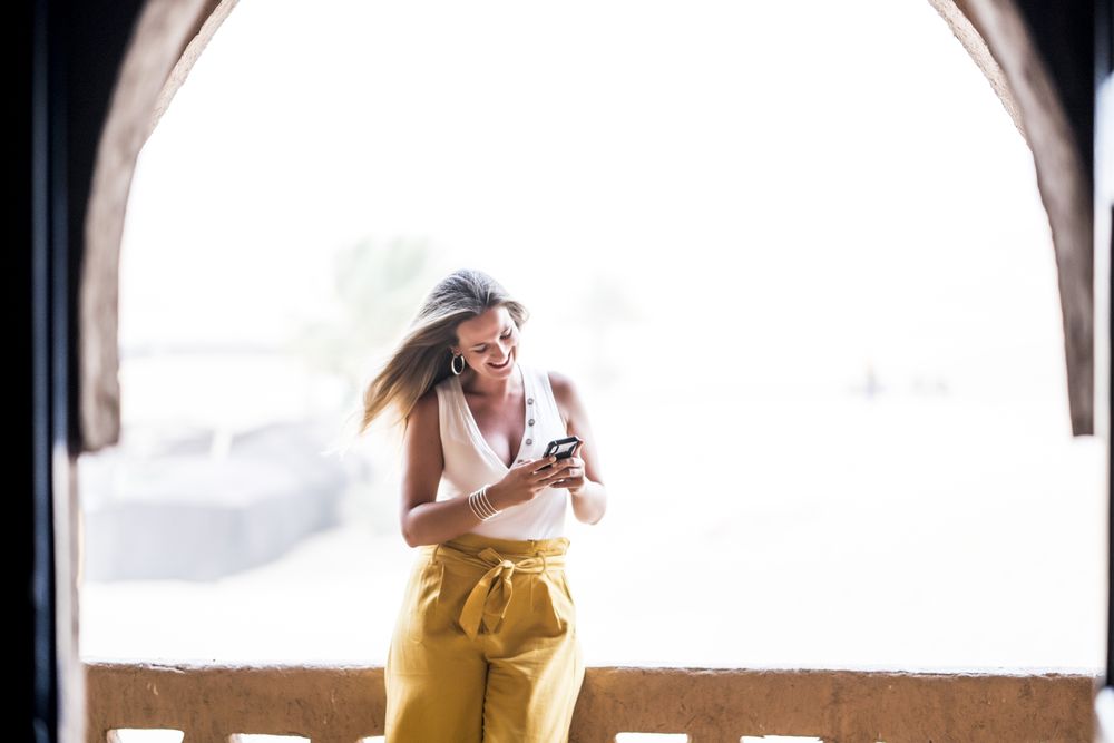 Woman using smartphone in balcony