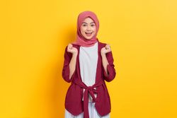 Happy woman in red headscarf with both hands up in anticipation