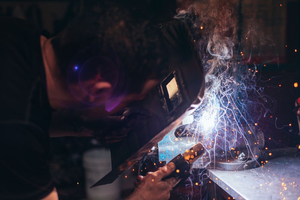 Professional welder in mask welding metal