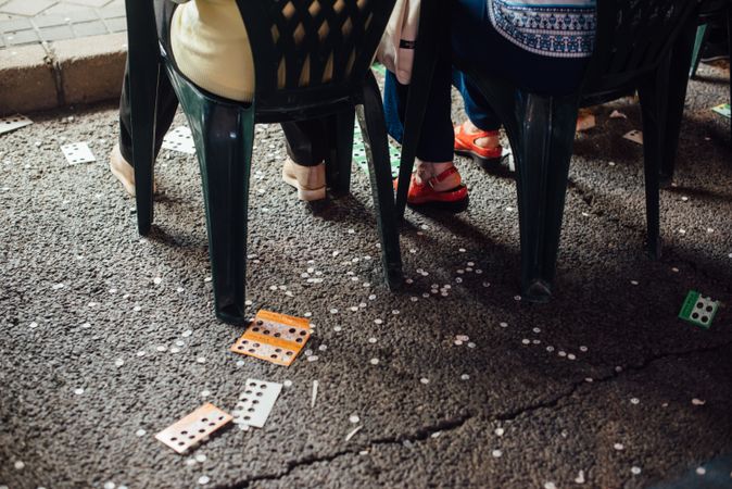 Crop people sitting on street during lottery on fairground