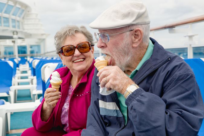 Happy Grey Haired Couple Adult Couple Enjoying Ice Cream On The Deck of a Luxury Passenger Cruise Ship.