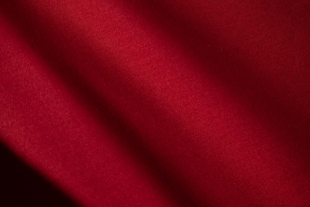Diagonal Wavy Red fabric background texture. shiny, glossy and elegant background.