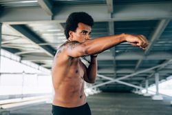 Black male athlete practicing throwing a punch during training