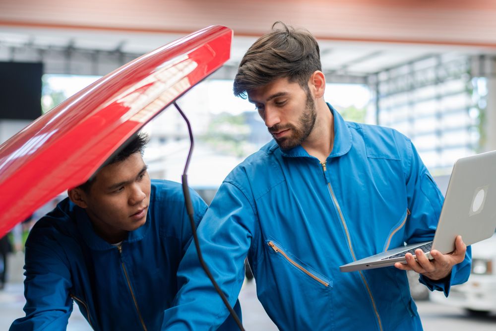 Mechanic man using laptop computer diagnostic to repair car