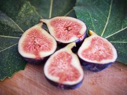 Halved figs near green leaves