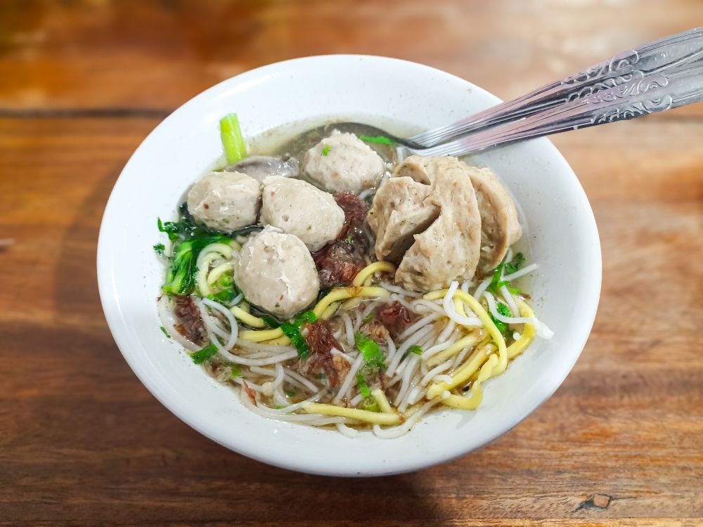 Indonesian Meatball Soup or Bakso Urat with Noodles in Bowl on Wooden Table