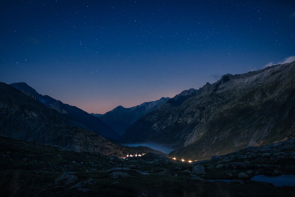 Lights above river in silent mountains at dusk
