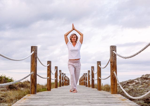 Cheerful woman exercising on timber path