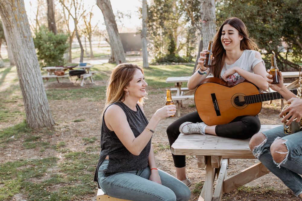Young musicians drinking beer in park