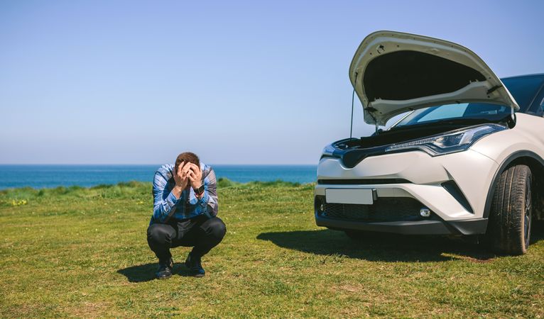 Young man desperate, car broken down
