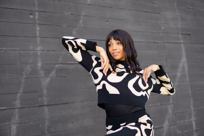 Trendy woman posing outside grey wall
