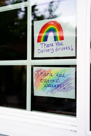 Close up of two hand lettered signs with rainbows showing gratitude during quarantine