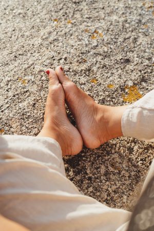 Person relaxing while sitting on stone