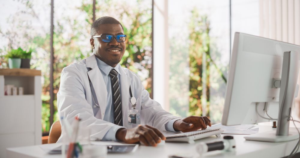 Black Medical Health Care Professional Looking at the Camera and Gently Smiling