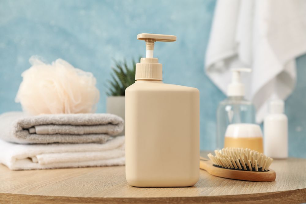 Bottle for liquid soap on wooden table. Personal hygiene concept