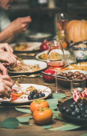 Group of people at festive fall dinner with wine, squash, olives