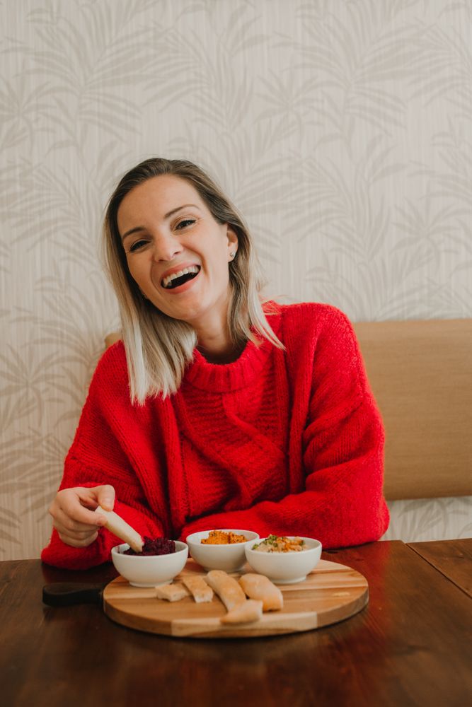 Woman smiling eating assorted food at table