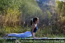 Female wearing sport clothes doing yoga pose outside 0y1xR0