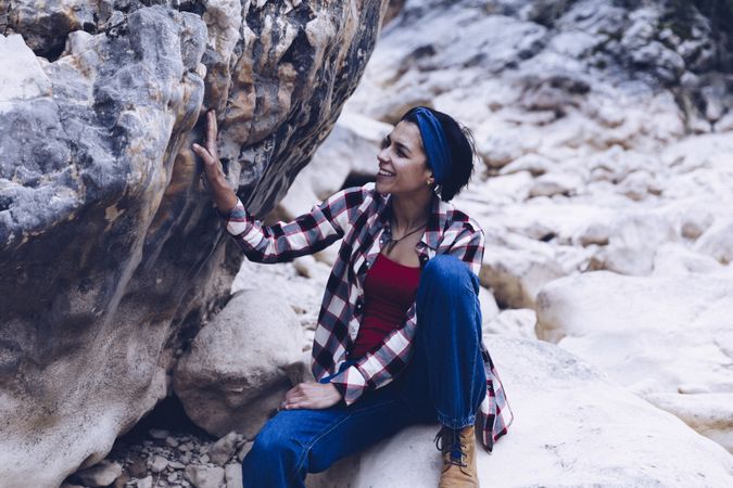 Positive woman sitting on stone