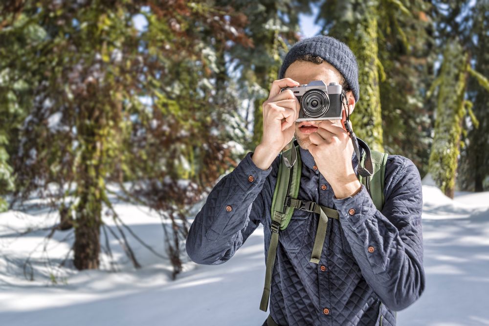 Tourist taking photo on camera while exploring nature in winter