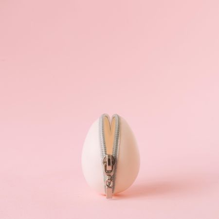 Easter egg with zipper on pastel pink background