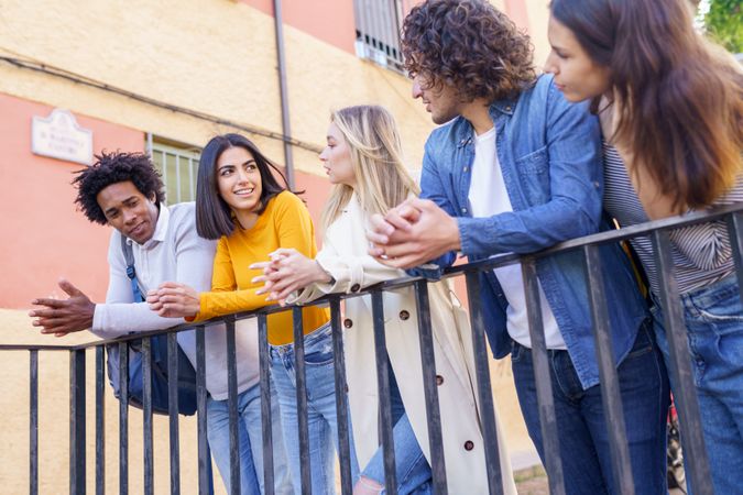 Portrait of happy male and female friends talking together outside