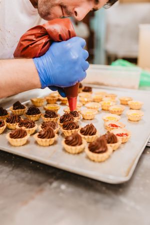 Crop baker squeezing dough on tray
