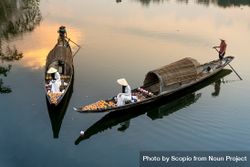 People with conical hats on boats in river at sunset 0KJ7yb