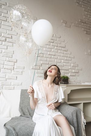 young woman with red lips in white dress smiling at camera