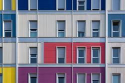 Facade of modern multicolored building with narrow windows