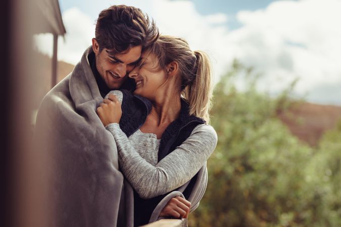 Couple on winter holiday embracing each other and smiling