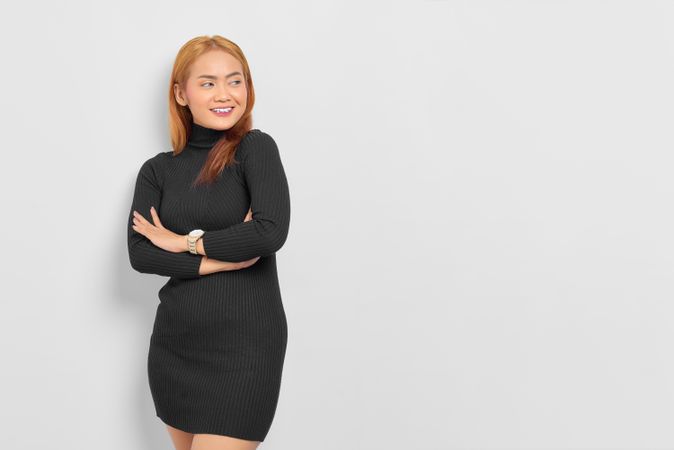 Smiling Asian woman with red hair and arms crossed over her chest with copy space