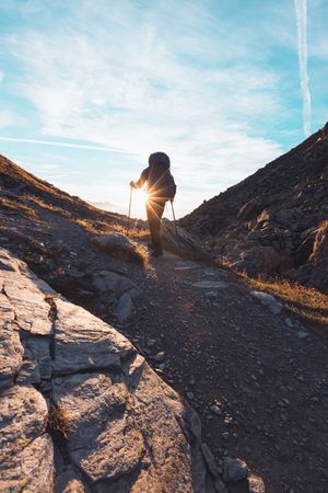 Silhouette of a man with backpack hiking in Switzerland at sunrise