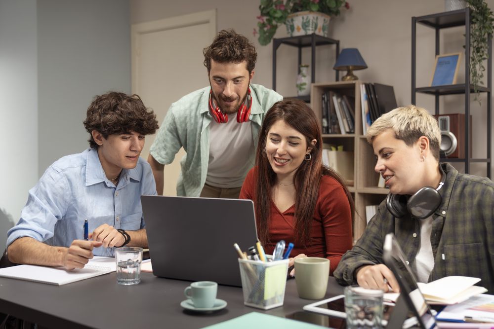 Young friends collaborating on laptop in modern home office smiling and brainstorming session