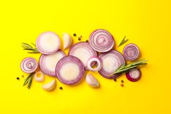 Flat lay composition with red onion rings and spices on color background