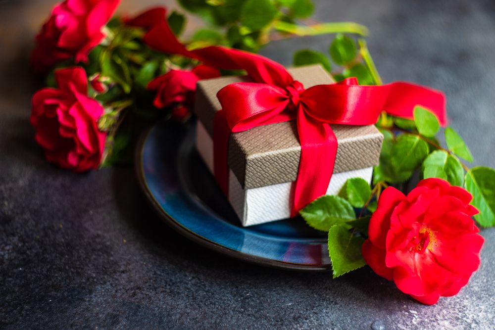 Table setting with red rose and present