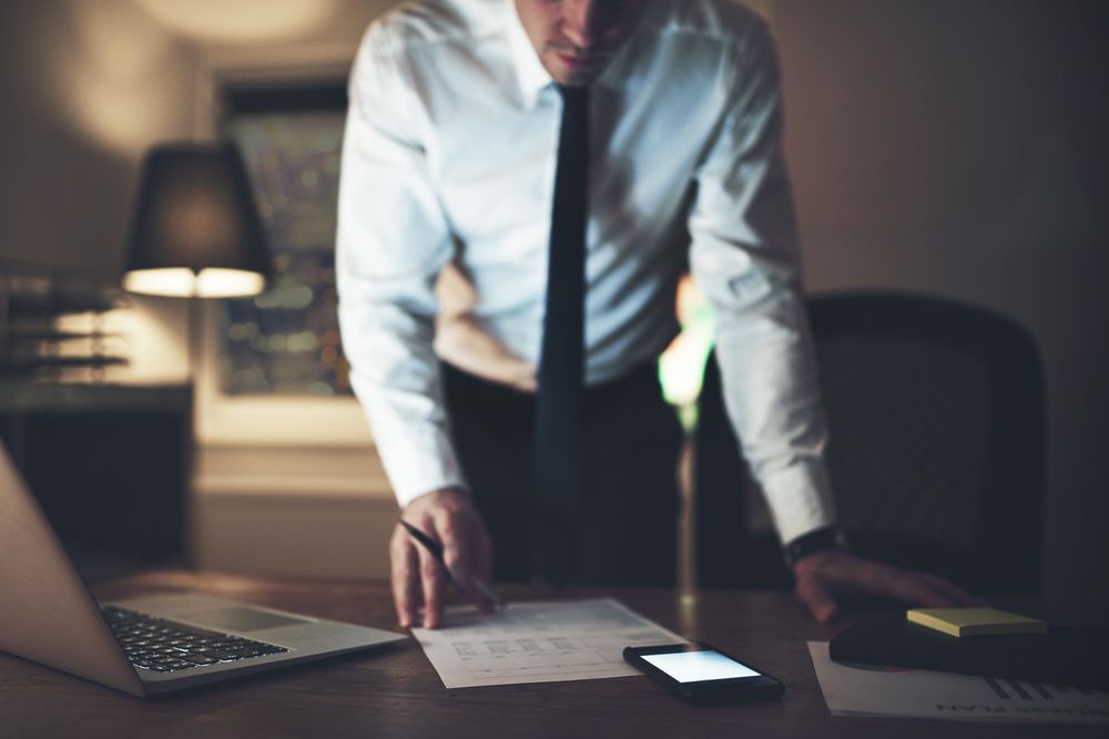Professional man standing and going over a document with a pen