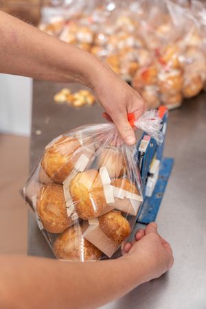 Hands closing cupcakes bag